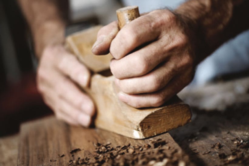 Les mains d'un menuisier travaillant le bois