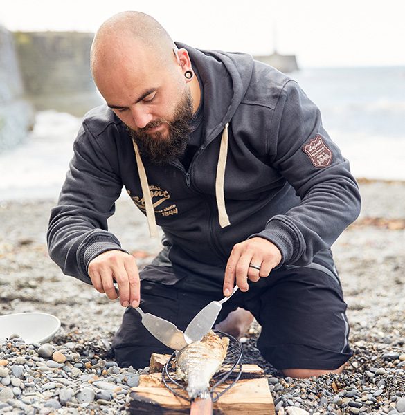 Nathan Davies préparant un poisson au bord de mer
